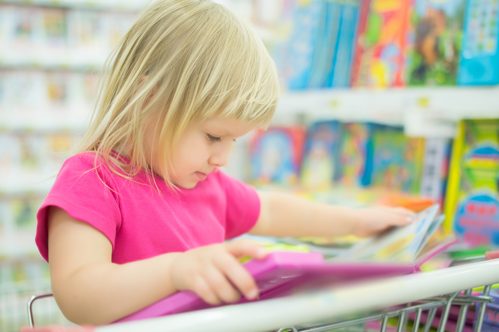 girl-reading-interactive-book-in-supermarket