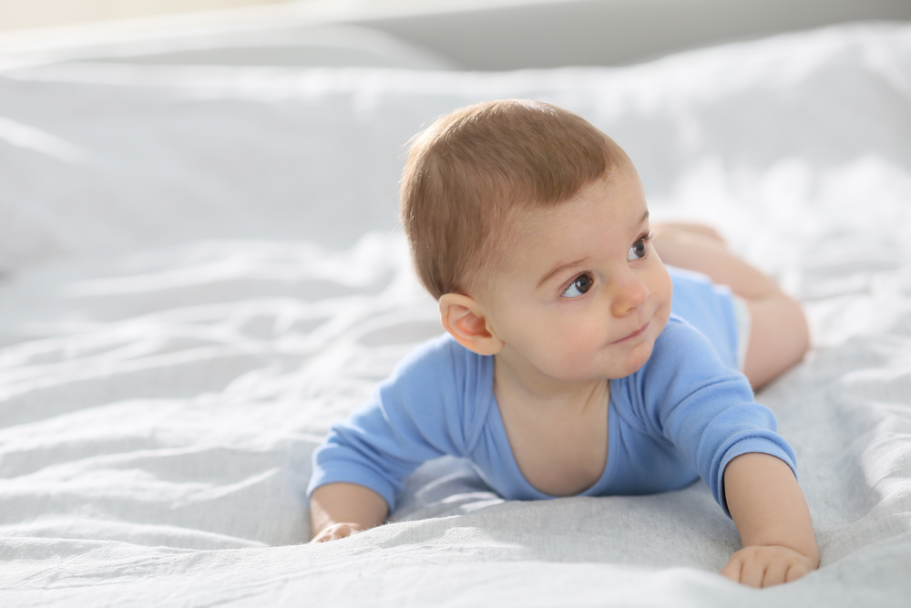 8-month-old-baby-boy-on-bed