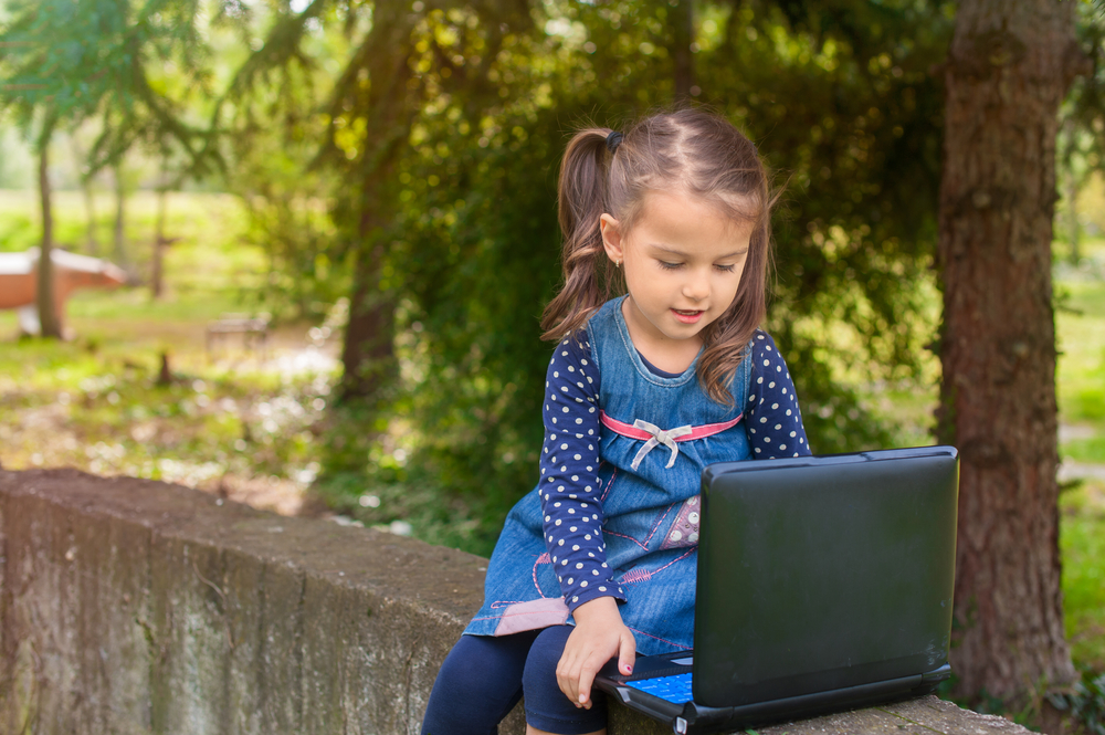 little-girl-learning-with-tablet-pc-in-the-park-outdoor