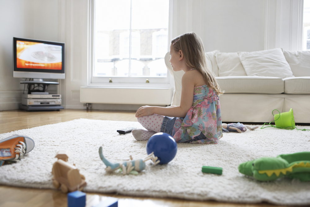 little-girl-watching-TV-with-her-toys-on-the-floor