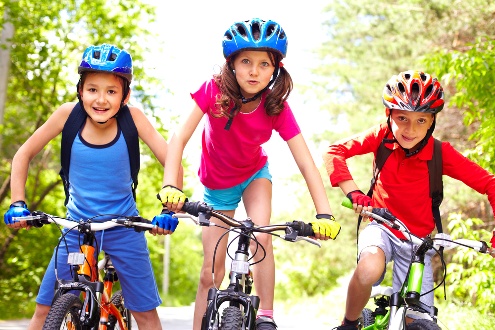 portrait-of-three-little-cyclists-riding-their-bikes