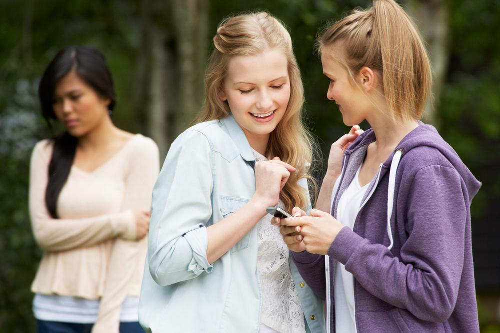 teenage-girl-being-bullied-by-text-message-on-mobile-phone-cyberbullying